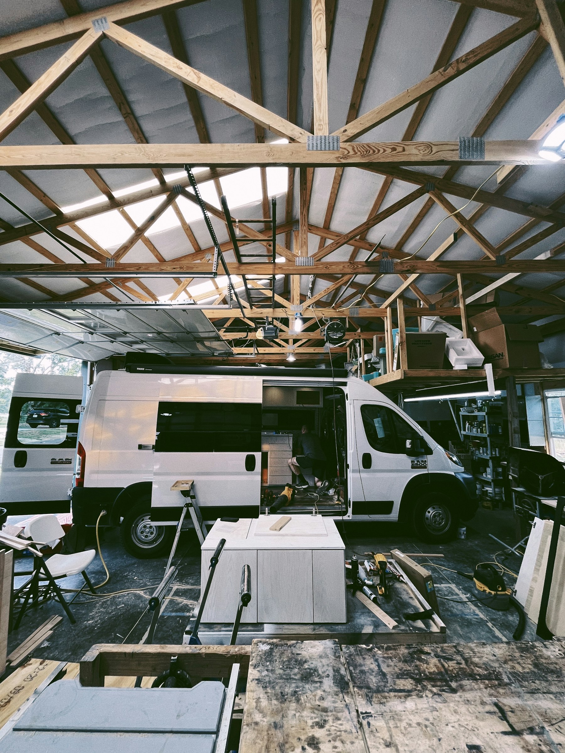 A white service van parked inside a workshop